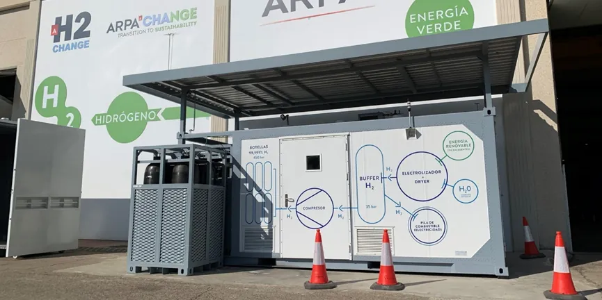 Photo of a compact containerised ARPA hydrogen refuelling station, its side showing the electrolyser, 35 bar buffer, compressor and 450 bar cylinders